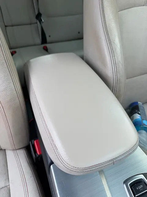 BMW leather center armrest after color-matched repair in Denver