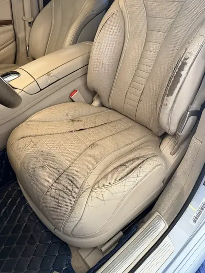 Deep crack in leather driver seat side bolster before repair in Denver