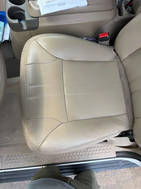 Leather driver seat after crack repair and color restoration in Denver